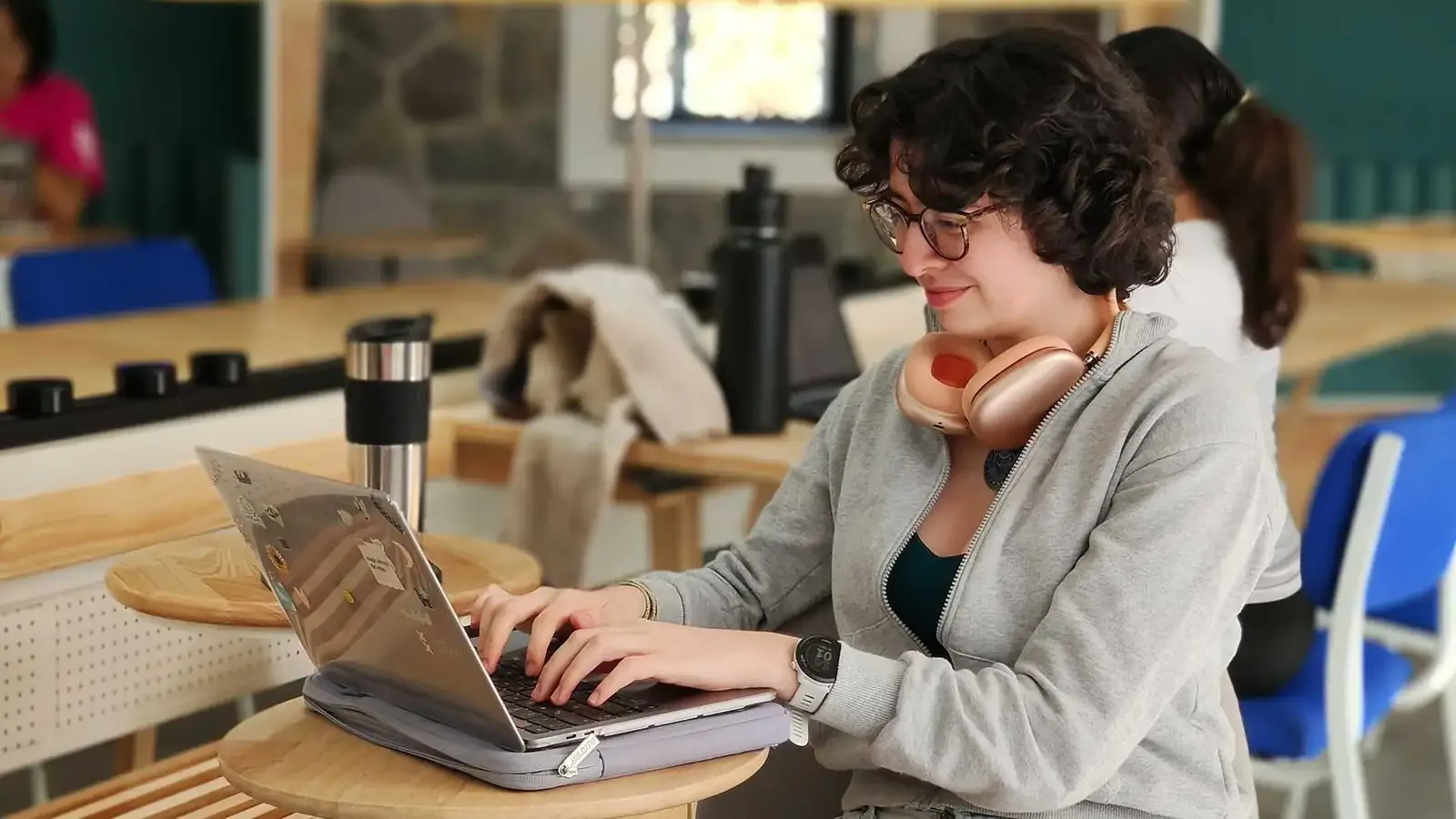 A student studying on a laptop in a MUWCI common room